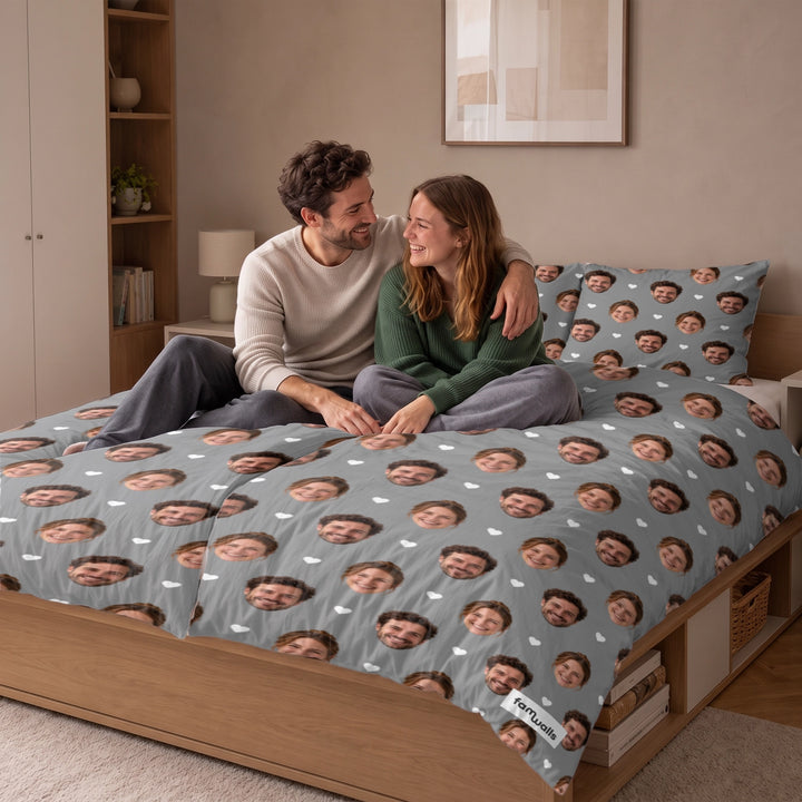 Couple assis sur un lit avec la parure personnalisée à visages sur fond gris market_france