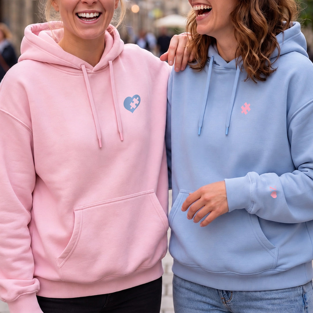 Amies souriantes en sweat à capuche rose et bleu clair avec motif puzzle | market_france